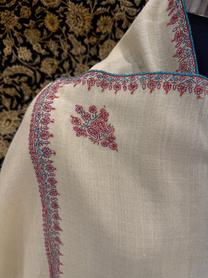 Close-up of a piece of fabric with intricate embroidery on a textured background