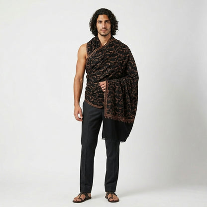 Man wearing a patterned scarf draped over his shoulders against a white background